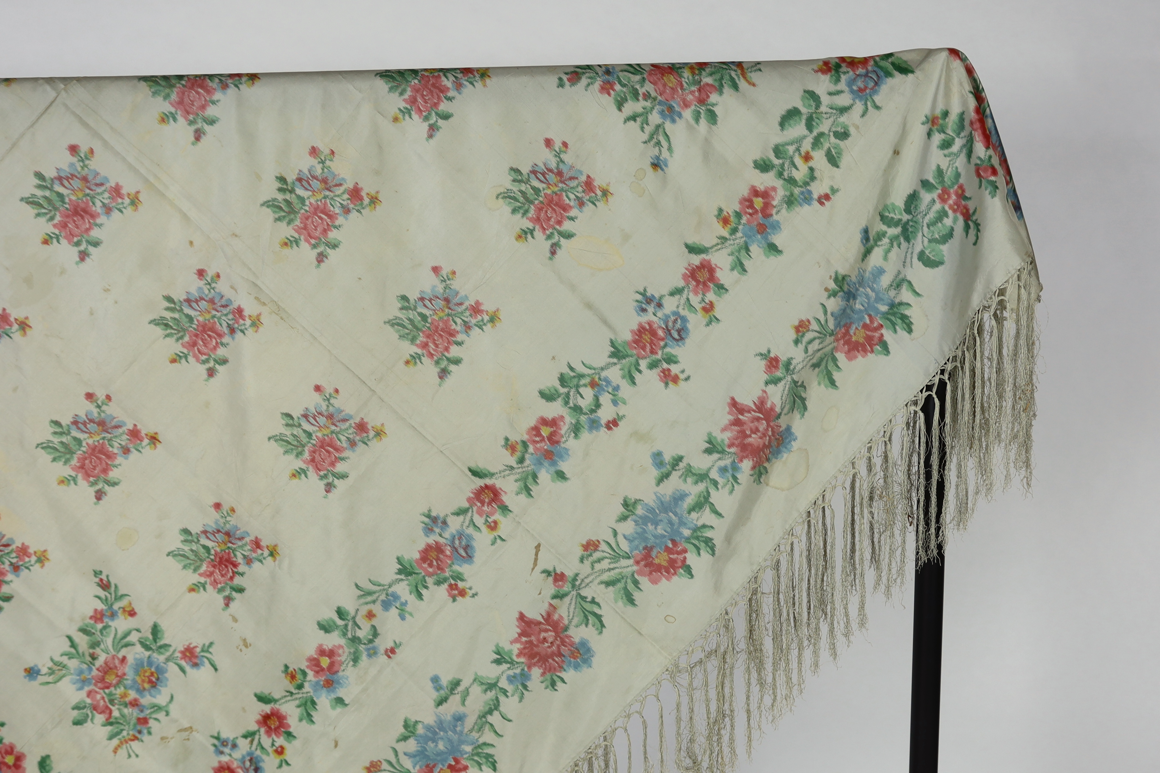 A French silk shawl, c.1800-1840, of a type modelled by Madame Recamier in the painting by François Gerard, printed on the warp thread into a rose pattern, with long fringing, 174 x 170cm